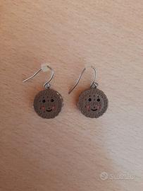 Orecchini pendenti a forma di cookies sorridenti.