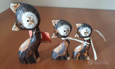 Tre statuette in legno a forma di gatto