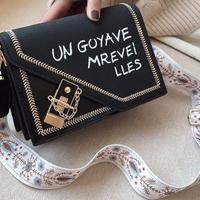 Borsa a tracolla con scritta e tracolla decorata