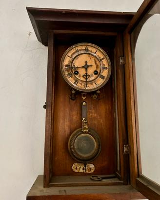 Antico orologio a pendolo da muro