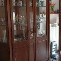 Vetrina in noce con ripiani in cristallo .