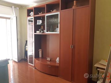 parete attrezzata, scrivania, divano e tavolino 