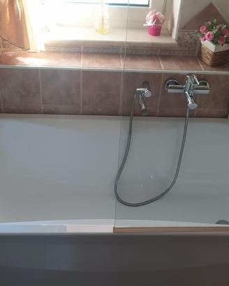vasca da bagno con miscelatore e parete in cristal