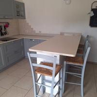 Cucina in legno con piano snack in quarzo.