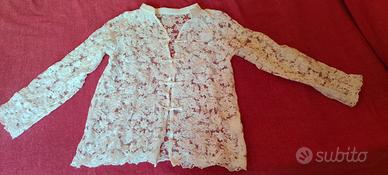 Camicia di pizzo bianca aperta davanti.
