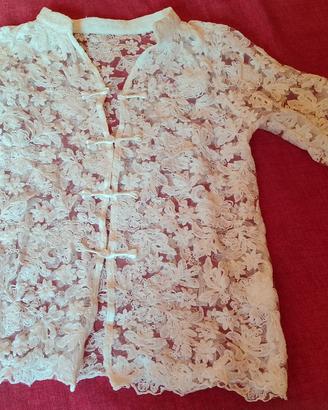 Camicia di pizzo bianca aperta davanti.