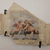 Parte di tegola antica con putti