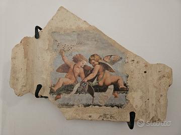 Parte di tegola antica con putti