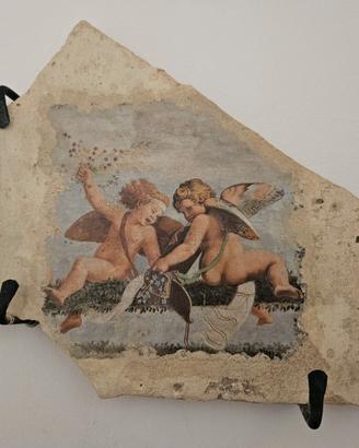 Parte di tegola antica con putti