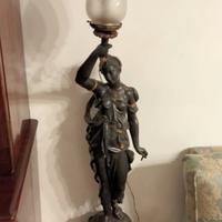 Antica lampada in bronzo con donna e torcia