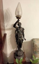 Antica lampada in bronzo con donna e torcia