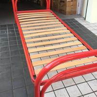 Letto rosso in ferro con rete a doghe