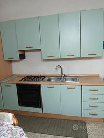 Cucina con lavello e piano cottura 