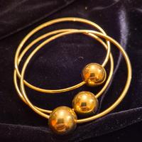 Tris di bracciali dorati con sfera