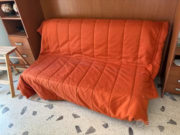 Divano letto a due piazze con copriletto.