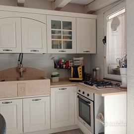 Cucina ad angolo con top in marmo ed elettrodom.