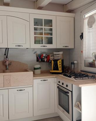 Cucina ad angolo con top in marmo ed elettrodom.