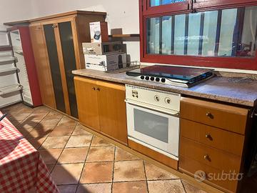 cucina con piano cottura forno e mobile