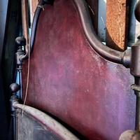 Vecchio letto singolo in ferro battuto con sponde