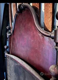 Vecchio letto singolo in ferro battuto con sponde