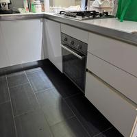 Cucina bianco laccato con penisola e cappa sospesa