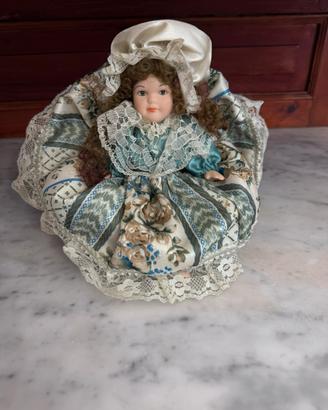 Bambola in ceramica con poltrona