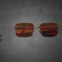 Occhiali da sole lente arancione aste dorate v