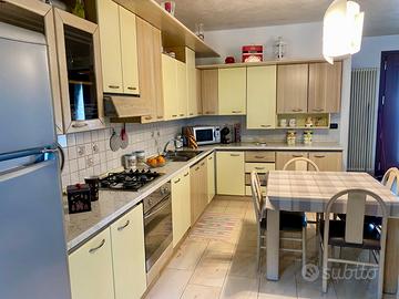 Cucina con elettrodomestici + tavolo e sedie
