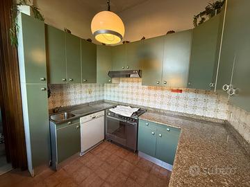 Cucina vintage con molti pensili e componenti