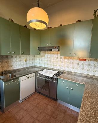 Cucina vintage con molti pensili e componenti