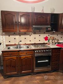 Cucina con forno e piano cottura e frigo da incass
