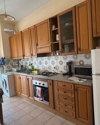 Cucina lineare in legno completa di tavolo e sedie