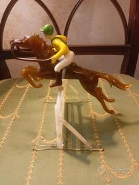 Fantino a cavallo che salta ostacolo in vetro
