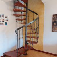 Scala a chiocciola in legno e ferro battuto.