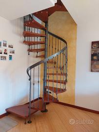 Scala a chiocciola in legno e ferro battuto.