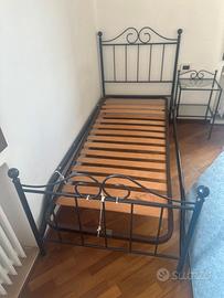 Letto con materasso e comodino.