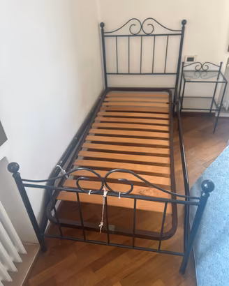 Letto con materasso e comodino.