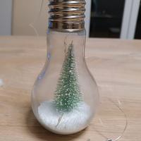 Lampadina con neve e abete