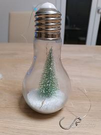 Lampadina con neve e abete