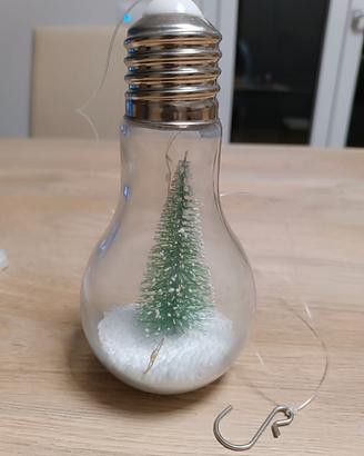 Lampadina con neve e abete