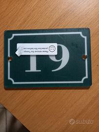 Numero civico 19 su sfondo verde