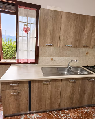 Cucina lineare completa con forno, piano cottura e
