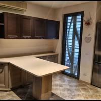 Cucina angolare bicolore con top in marmo