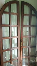 Coppia di porte in legno con vetri e arco su