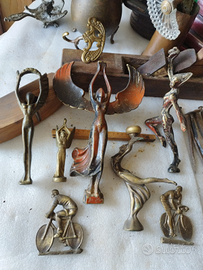 Antiche statue in bronzo di donne alate e ciclisti