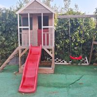 Casetta in legno con scivolo e altalena