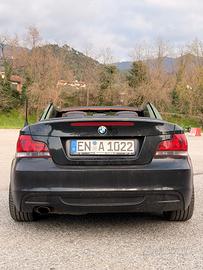 BMW 118i Cabrio – Nero / interni in pelle marrone.