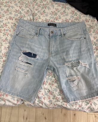 Pantaloncini jeans chiari strappati con toppa