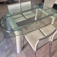 Tavolo in cristallo con sedie in pelle