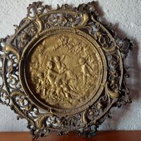 Antico piatto in bronzo con figure in rilievo